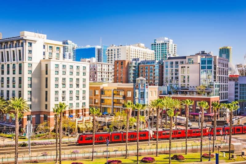 Modern train passing through the scenic San Diego cityscape.